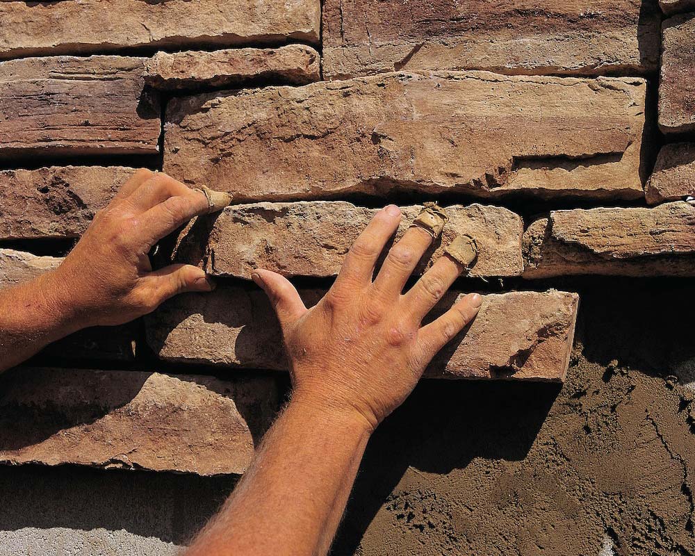 Stone Vaneer Hands Installing Stone